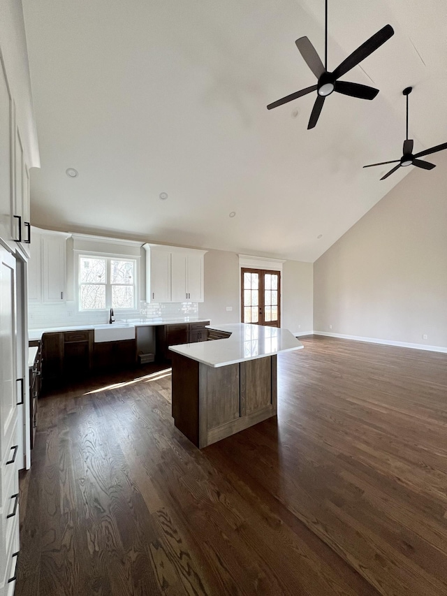 kitchen featuring white cabinetry, a large island, sink, dark hardwood / wood-style flooring, and lofted ceiling