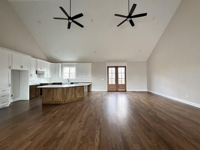 kitchen with french doors, a center island, high vaulted ceiling, dark hardwood / wood-style floors, and white cabinets