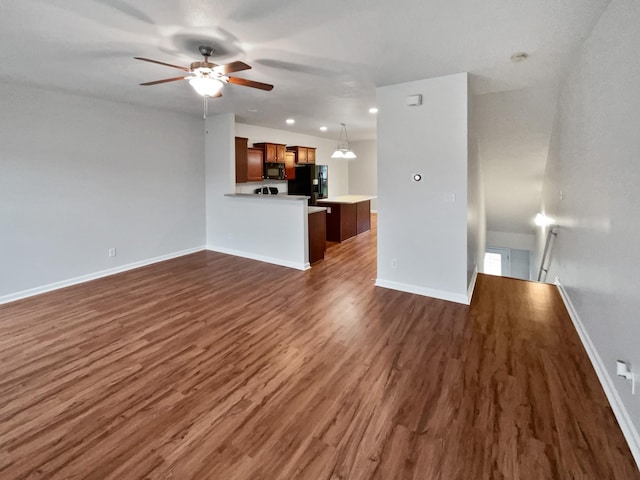 unfurnished living room with ceiling fan and dark wood-type flooring