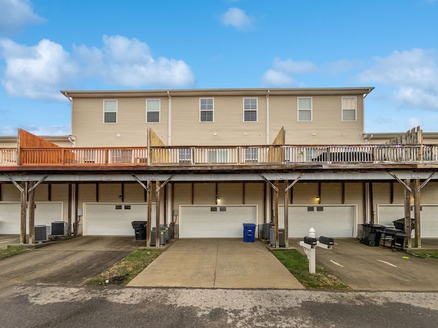 rear view of property with a garage and central air condition unit