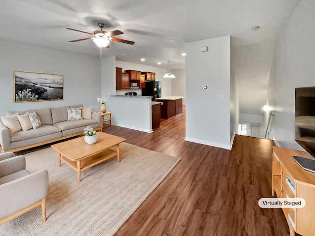 living room featuring ceiling fan and dark hardwood / wood-style flooring