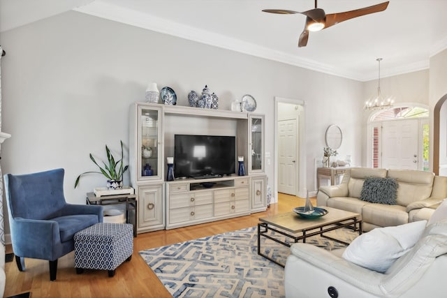 living room with ceiling fan with notable chandelier, light wood-type flooring, and crown molding