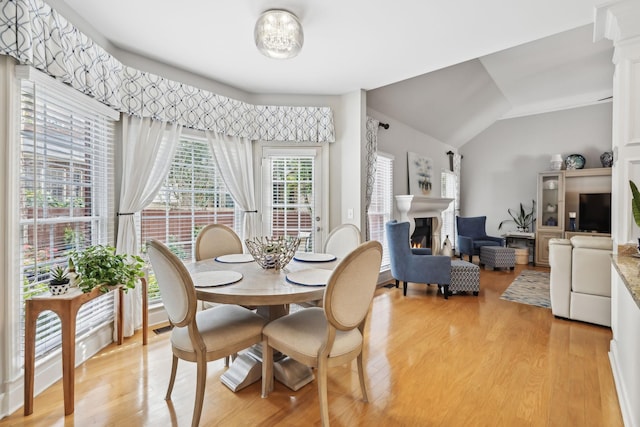 dining space featuring vaulted ceiling and light hardwood / wood-style flooring