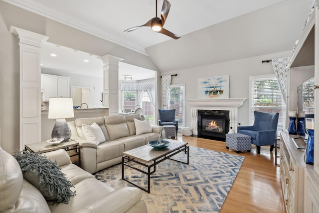 living room with ceiling fan, a healthy amount of sunlight, light hardwood / wood-style floors, and vaulted ceiling