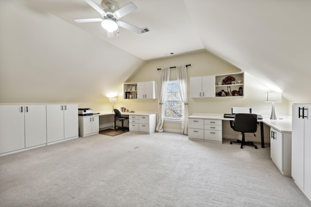 carpeted home office with ceiling fan, built in desk, and lofted ceiling