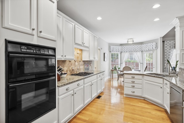 kitchen with white cabinets, light wood-type flooring, stainless steel appliances, and sink