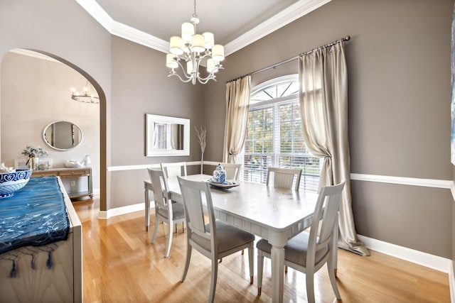 dining area with a notable chandelier, wood-type flooring, and ornamental molding