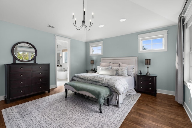 bedroom with multiple windows, dark wood-type flooring, connected bathroom, and a chandelier