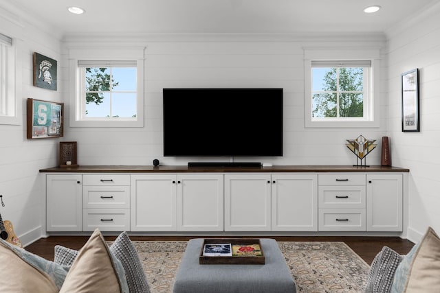 living room featuring dark wood-type flooring and crown molding