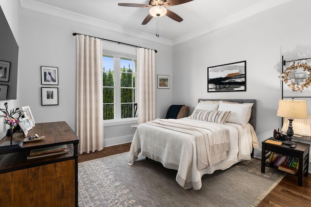 bedroom with crown molding, dark hardwood / wood-style floors, and ceiling fan