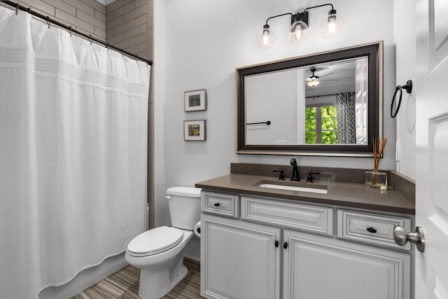 bathroom with vanity, toilet, ceiling fan, and walk in shower