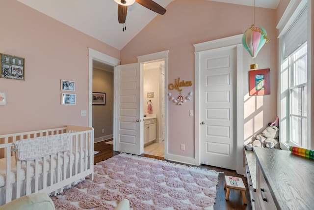 bedroom with vaulted ceiling, a nursery area, ensuite bathroom, and ceiling fan