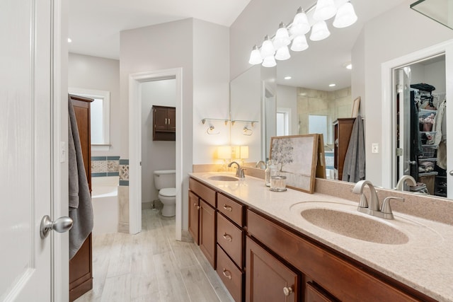 full bathroom featuring hardwood / wood-style flooring, vanity, toilet, and shower with separate bathtub