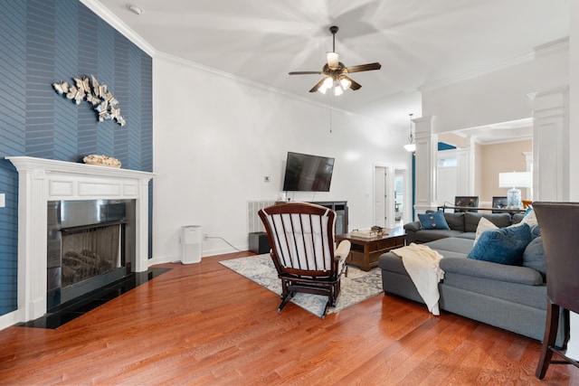 living room with crown molding, ceiling fan, and wood-type flooring