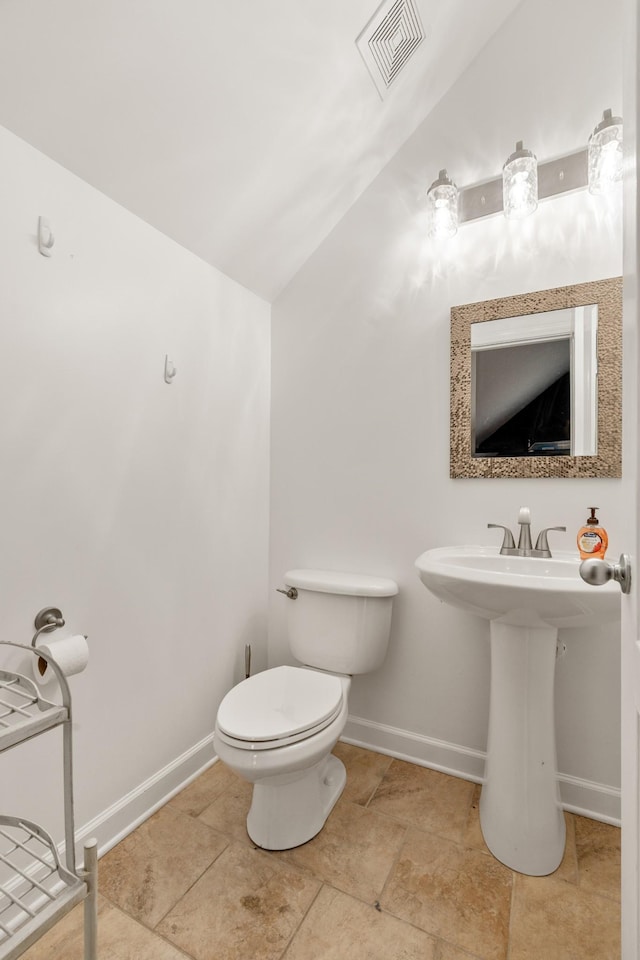 bathroom featuring toilet and lofted ceiling