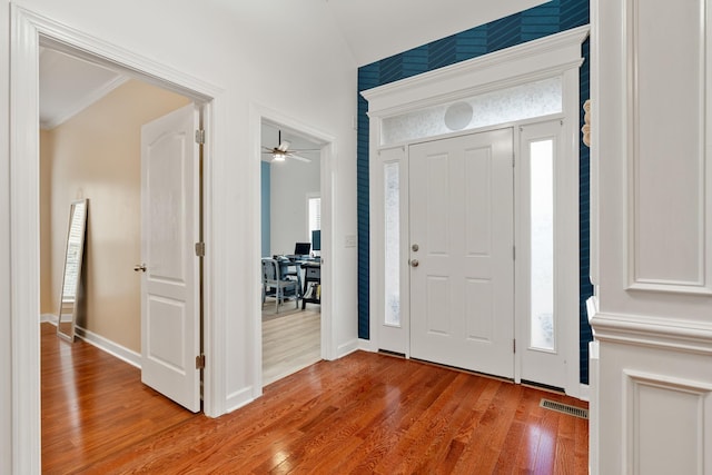 entryway featuring ceiling fan, light wood-type flooring, and ornamental molding