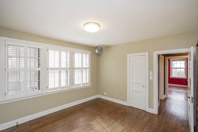 unfurnished room with dark hardwood / wood-style flooring