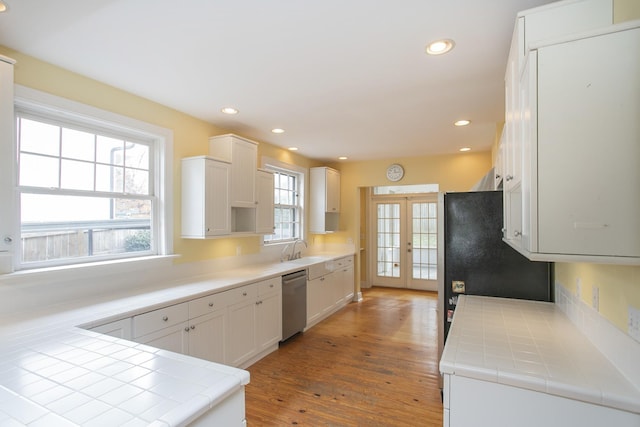 kitchen with white cabinets, hardwood / wood-style floors, tile countertops, and plenty of natural light