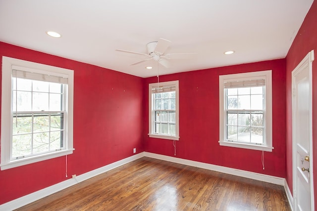 spare room featuring ceiling fan, a healthy amount of sunlight, and wood-type flooring