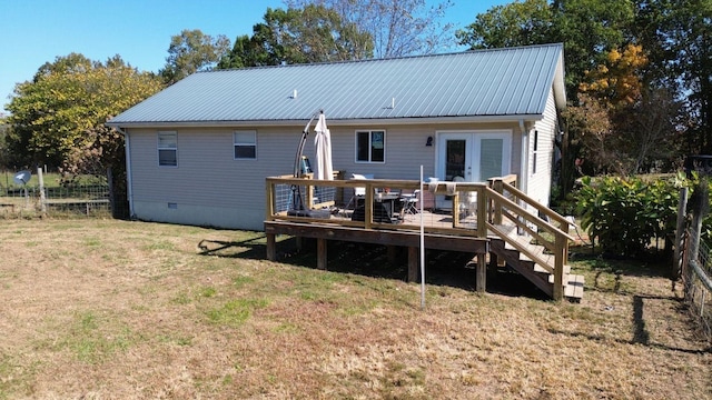 back of property with a wooden deck, a yard, and french doors