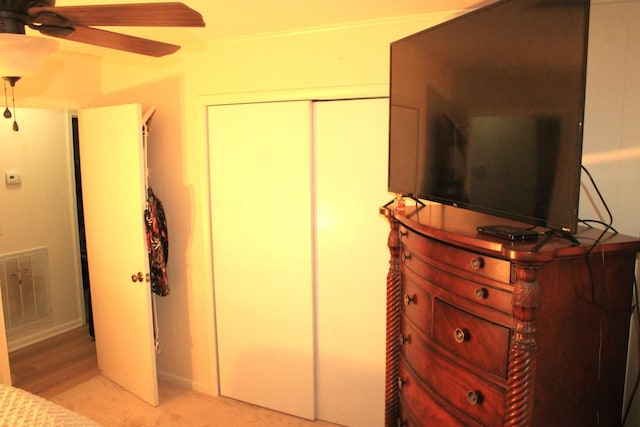 bedroom with ceiling fan, a closet, and light hardwood / wood-style floors