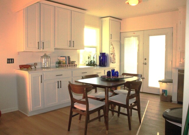 kitchen with white cabinets, french doors, and light hardwood / wood-style flooring