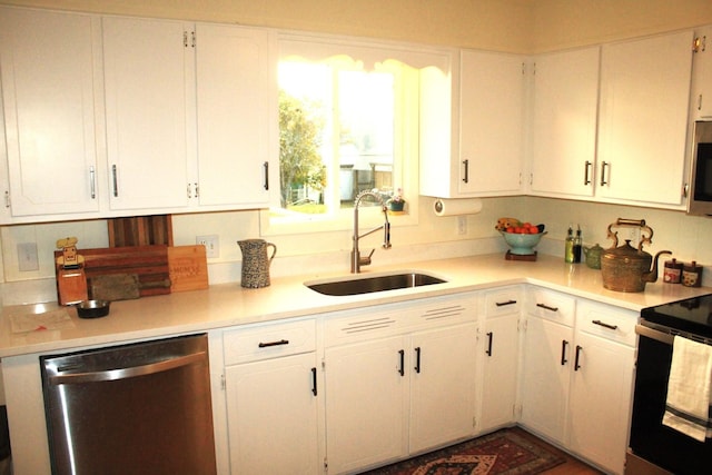 kitchen with appliances with stainless steel finishes, white cabinetry, and sink