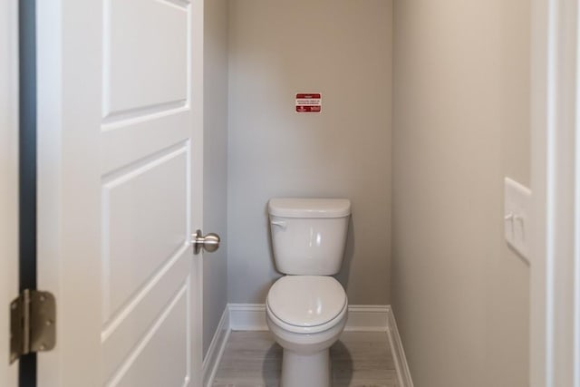 bathroom with toilet and wood-type flooring