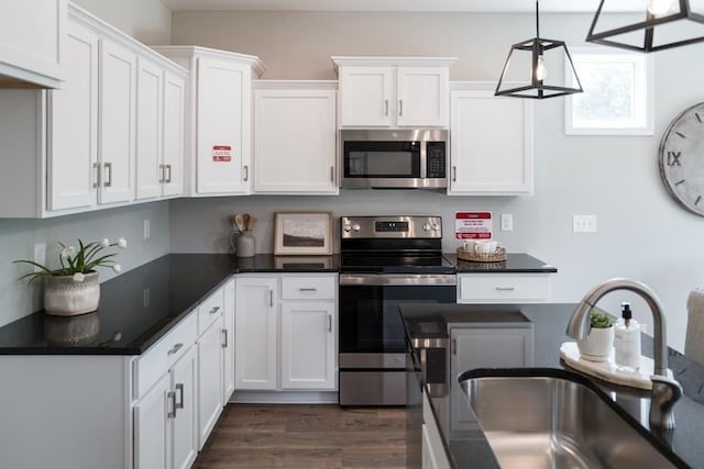 kitchen featuring sink, stainless steel appliances, dark hardwood / wood-style flooring, decorative light fixtures, and white cabinets