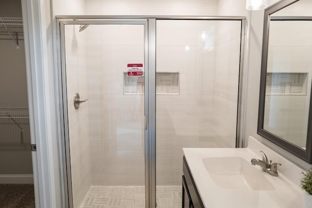 bathroom with vanity and a shower with door