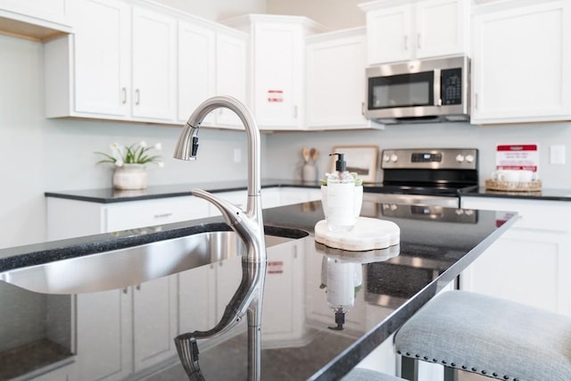 kitchen with sink, white cabinetry, and stainless steel appliances