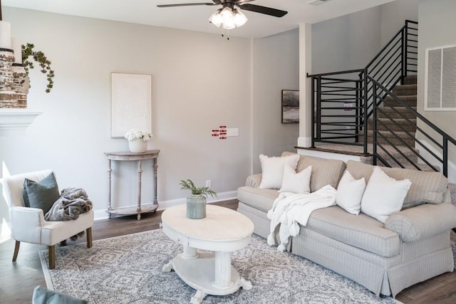 living room with ceiling fan and dark wood-type flooring