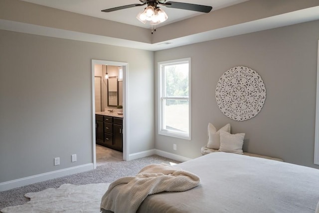 carpeted bedroom with ceiling fan and ensuite bathroom