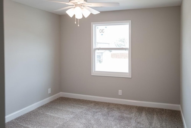 carpeted empty room featuring ceiling fan and a wealth of natural light