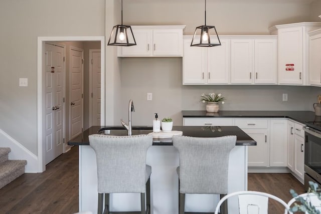 kitchen featuring pendant lighting, white cabinets, sink, a kitchen island, and dark hardwood / wood-style flooring