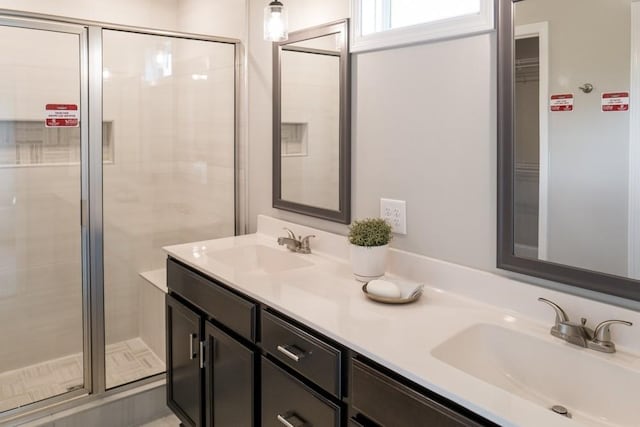 bathroom with vanity and a shower with door