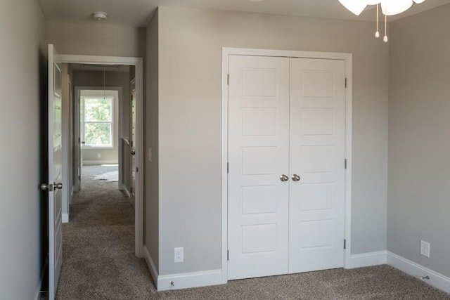 unfurnished bedroom featuring a closet and dark carpet