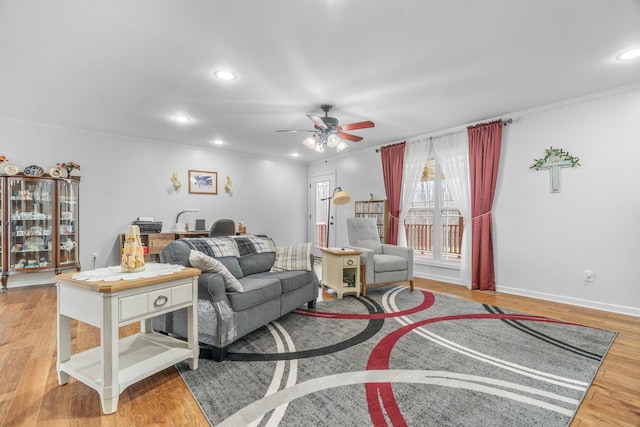 living room with ceiling fan, light hardwood / wood-style floors, and ornamental molding