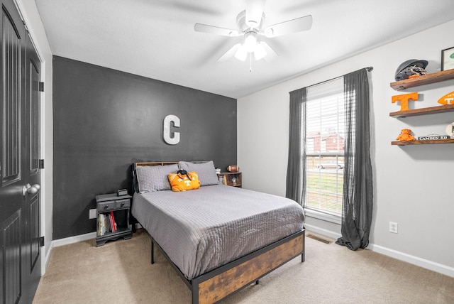 bedroom with ceiling fan, a closet, and light colored carpet