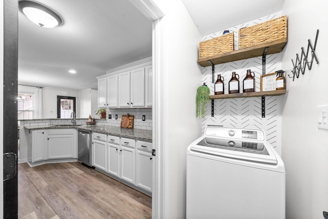 laundry area featuring light hardwood / wood-style floors, sink, and washer / clothes dryer