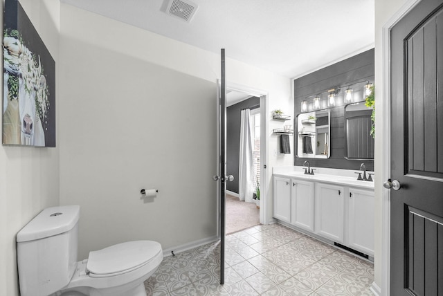 bathroom featuring tile patterned flooring, vanity, and toilet