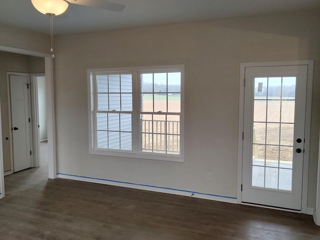 interior space featuring ceiling fan, a healthy amount of sunlight, and dark wood-type flooring