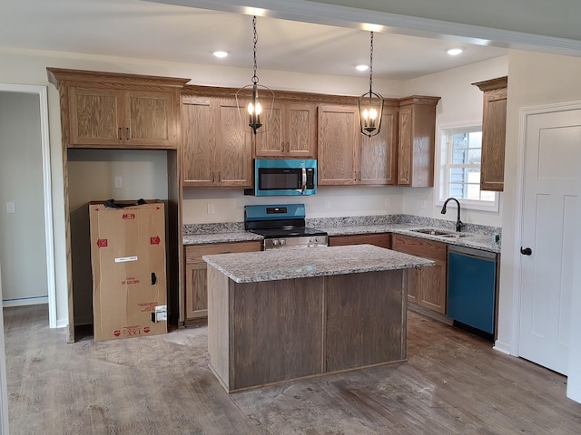 kitchen with pendant lighting, sink, a kitchen island, wood-type flooring, and stainless steel appliances