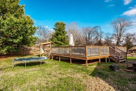 view of yard featuring a deck and a trampoline