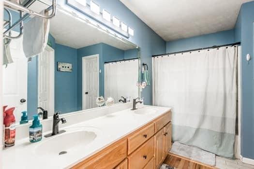 bathroom with shower / tub combo with curtain, vanity, and wood-type flooring