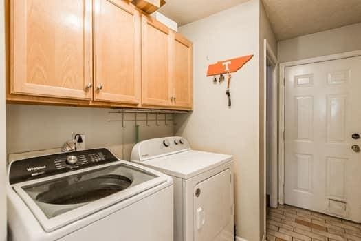 laundry room with washing machine and dryer and cabinets