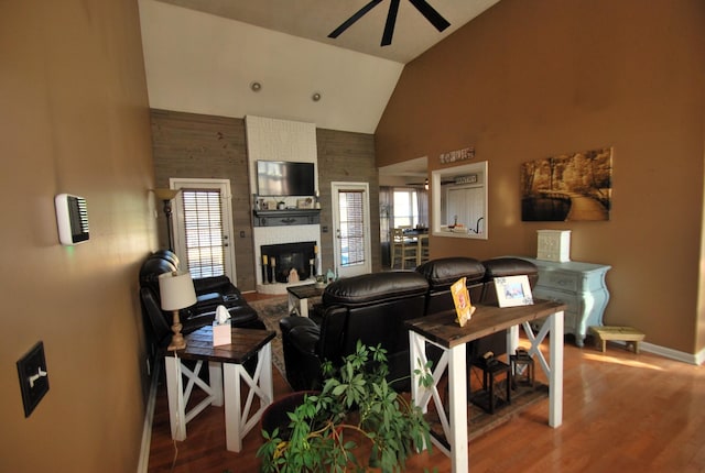 living room featuring a fireplace, vaulted ceiling, ceiling fan, wood-type flooring, and a healthy amount of sunlight