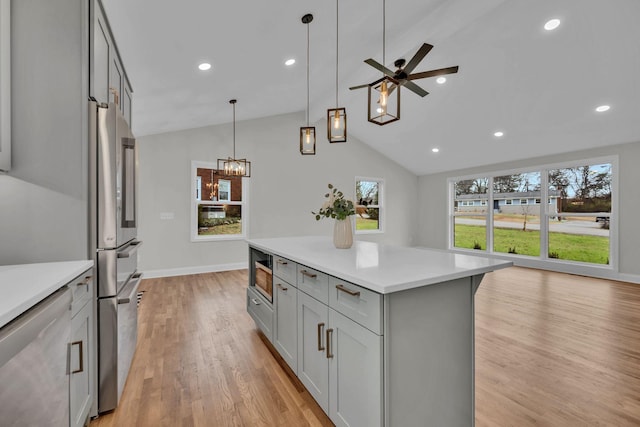 kitchen with a wealth of natural light, stainless steel appliances, gray cabinets, and light countertops