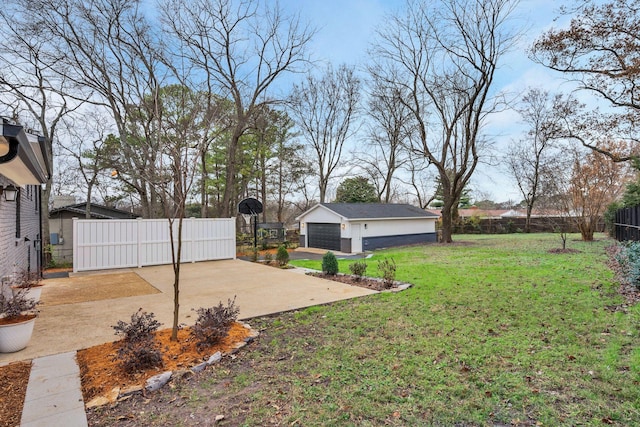 view of yard featuring a gate, a garage, an outdoor structure, and fence