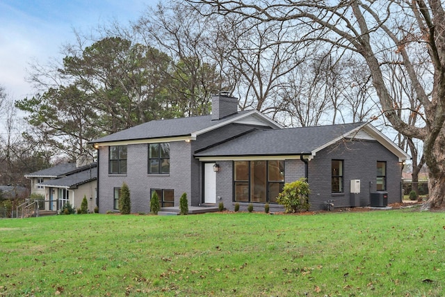 view of front of house featuring central AC and a front lawn